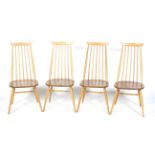 A set of four mid-century blonde Ercol Goldsmith stick back chairs.