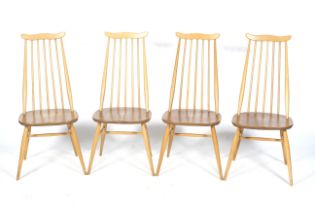 A set of four mid-century blonde Ercol Goldsmith stick back chairs.