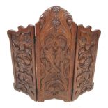 An Arts & Crafts carved dark oak three part folding screen.