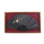An Edwardian black folding fan.