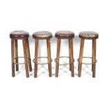 A set of four leather and wood bar stools.