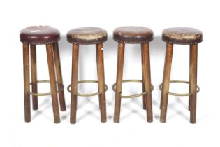 A set of four leather and wood bar stools.