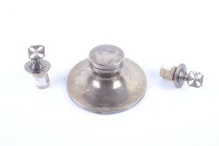 A George V silver inkwell and a pair of bottle stoppers.