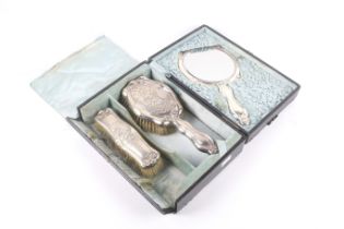 An Edwardian silver mounted shaped-oblong three piece dressing table set.