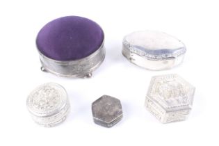 An Edwardian silver mounted pin cushion and four white metal boxes.