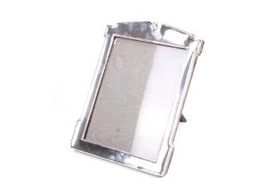 A silver mounted shaped-rectangular easel-back photograph frame.