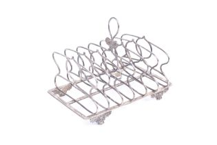 A George IV silver toast rack with a central cartouche shaped loop handle,
