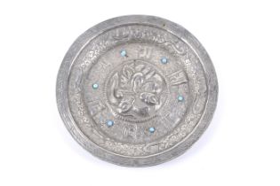 An Indian turquoise and white metal embossed round dish.