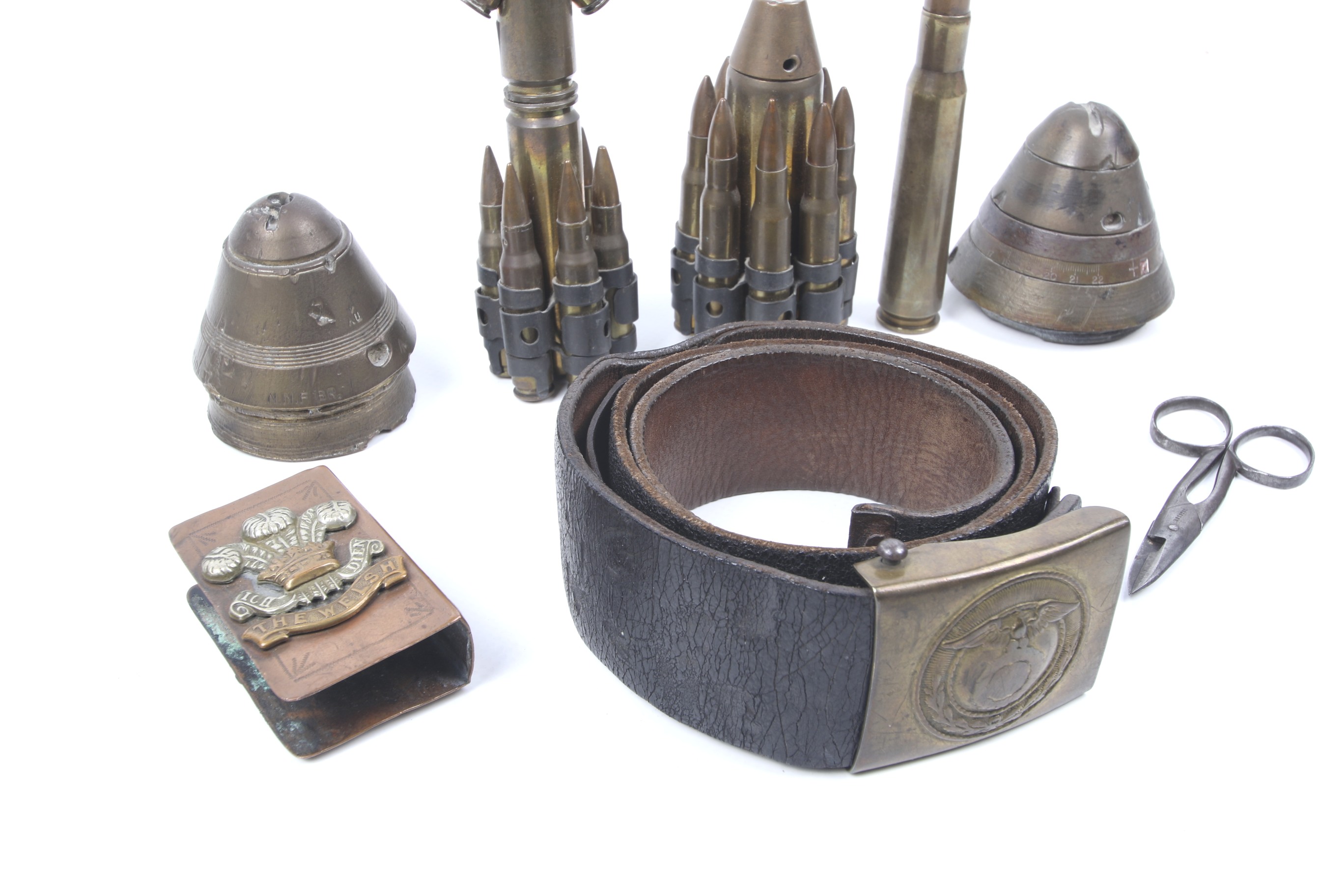 A group of military items. Including a leather belt with buckle, trench art pieces, shell caps, etc. - Image 2 of 2