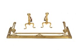 A early 20th century brass fender and a pair of brass fire dogs.