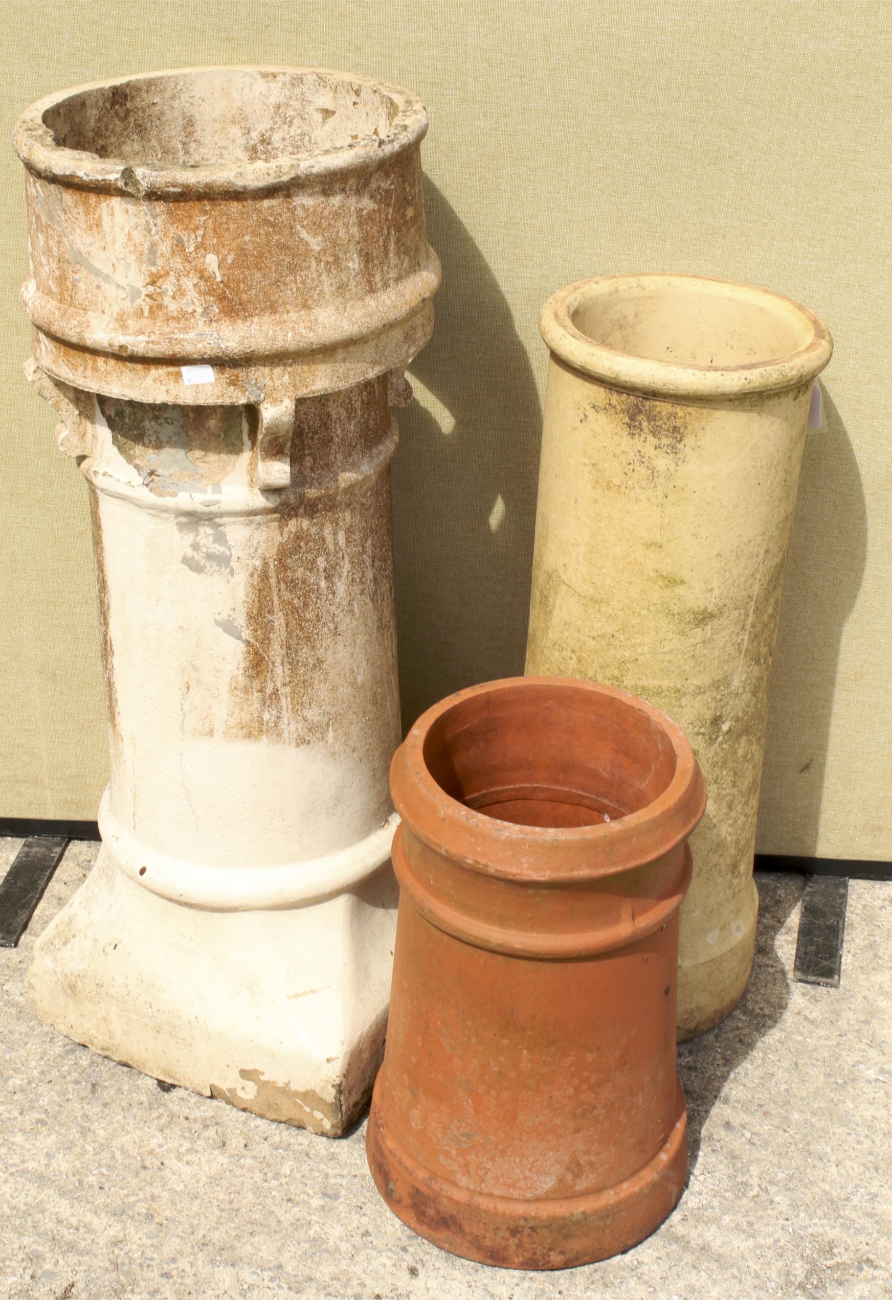 Three chimney pots. Comprising two cylindrical examples and one on a square base. Max.