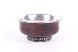 A late 19th/20th century Tibetan white metal and burl wood ceremonial tea bowl.