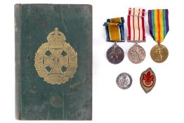 Three WWI and later medals, a badge and a book.