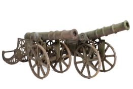 A pair of cast iron cannons. On wheels with rear supports, stamped RMI, H56cm x L160cm.