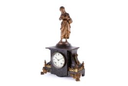 A Victorian slate mantel clock. Surmounted by a gilt metal figure reading a book.