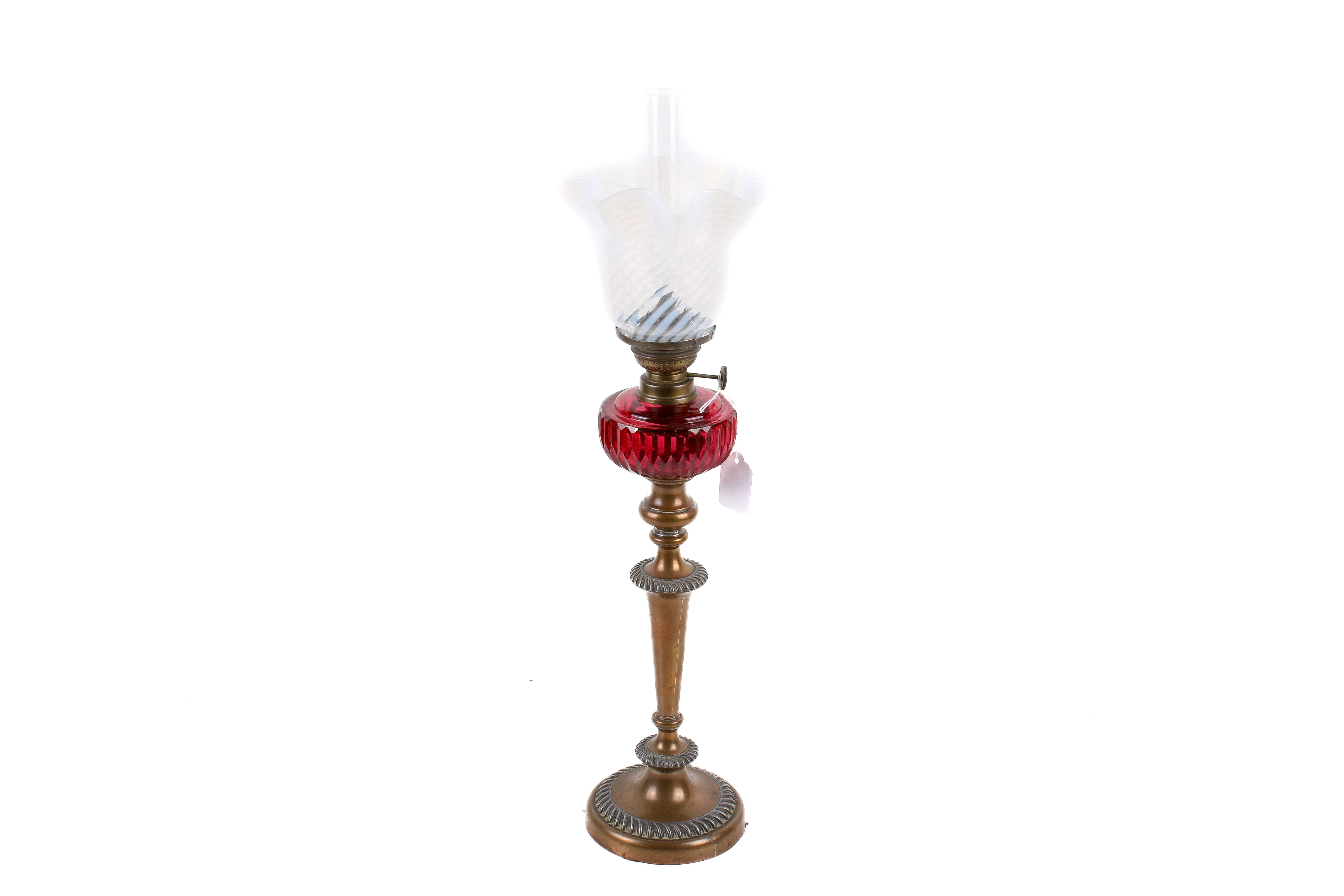 A brass candlestick/oil lamp. With cranberry glass reserve and opaline shade, H59cm.