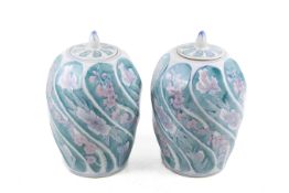A pair of ceramic jars and covers.