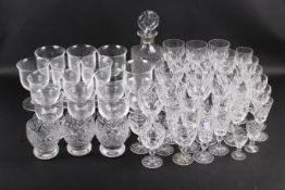 A large collection of drinking glasses and a decanter.