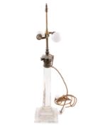 A glass table lamp base in the form of a column. With stepped square base and brass Corinthian top.