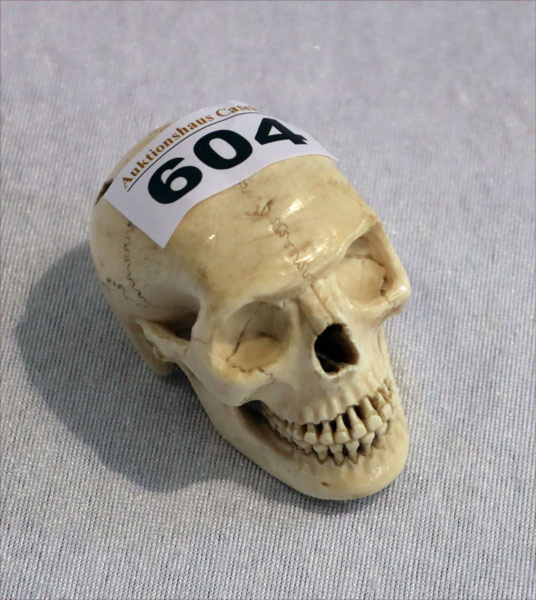 Miniatur eines Totenkopfes, ev. aus Knochen, H 4,5 cm, T 6,5 cm