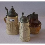 Konvolut: 2 Steingut Bierkrüge mit figürlichem Reliefdekor und Zinndeckel, H 23/25 cm, und