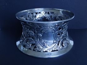 An Edwardian crested silver dish ring, the openwork sides embossed with foliage and scrolls,