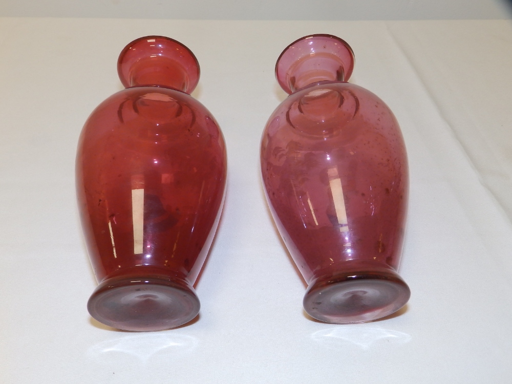 A pair of 'Mary Gregory' cranberry glass vases with coloured enamel decoration, one depicting a - Image 2 of 3