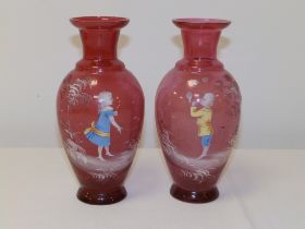 A pair of 'Mary Gregory' cranberry glass vases with coloured enamel decoration, one depicting a
