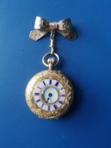 A lady's 18ct gold half hunter fob watch with pink enamelled chapter ring to the leaf-scroll