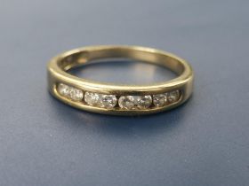 A diamond set yellow metal half eternity ring. Finger size L/M.