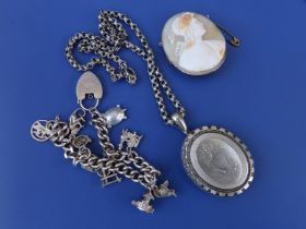 A Victorian white metal locket on chain, a charm bracelet and a cameo. (3)