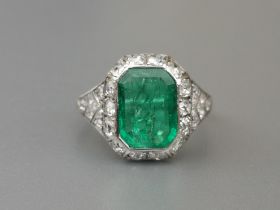 A rectangular emerald & diamond cluster ring, the chevron shoulders pave set with small diamonds