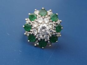 An emerald & diamond set 18ct white gold target cluster ring. Finger size N.