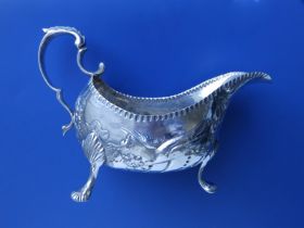 A George III Irish silver sauceboat, embossed decoration depicting birds & flowering foliage, a