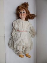 A French bisque head girl doll, with fixed blue paperweight eyes, composition body with jointed wood