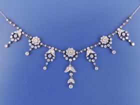 A diamond set platinum necklace, of fringe form comprising seven millegrain set flowerhead cluster