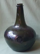 A very large onion shaped 17thC glass bottle with heraldic seal, circa 1690 - the section around the