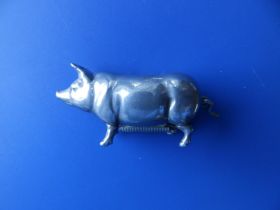 A silver plated pig tape measure, 2" across.