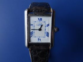 A cased lady's silver Must de Cartier rectangular dial wrist watch having white dial with blue roman