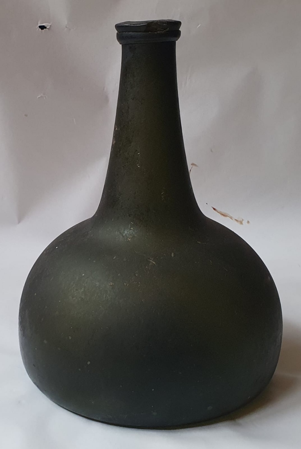 An antique onion shaped glass bottle , 7.75" high.