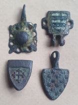 A group of medieval heraldic pendants and mount, the mount depicting the arms of the Grey family,