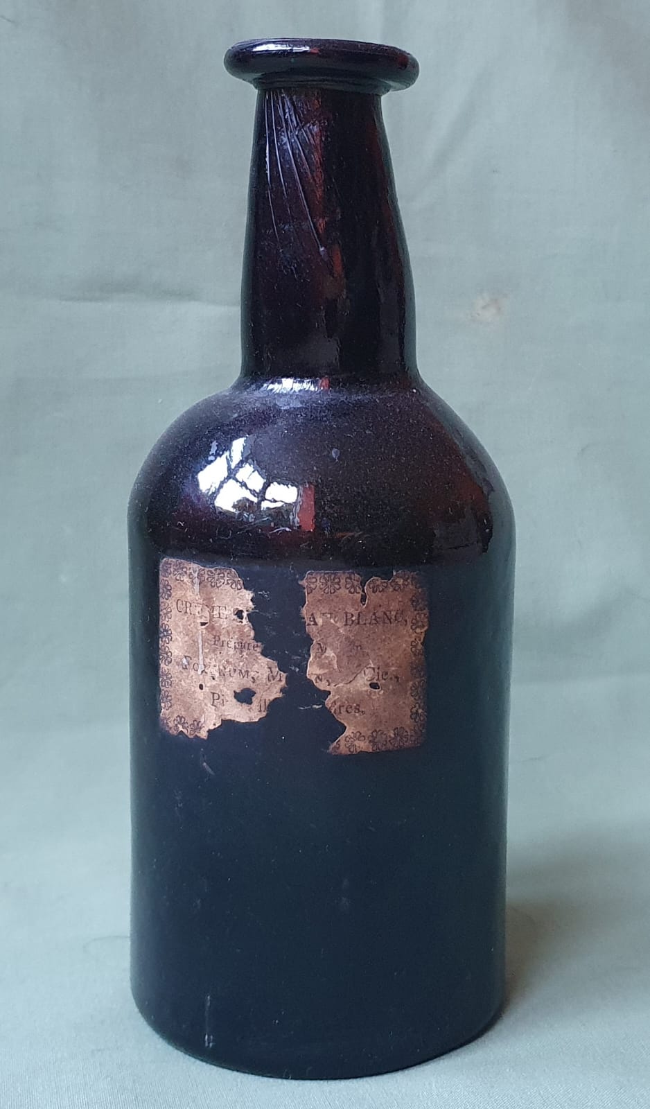 A glass bottle with remains of a paper label - Fortnum Mason, 8" high.