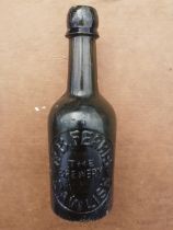 A press moulded green glass ale bottle - R.B. Ferris, Dawlish.