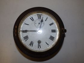 A ship's clock with (cracked) white enamelled dial, subsidiary seconds, 7" overall diameter.