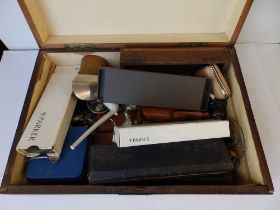A wooden box containing a shoe horn, a horn beaker and other collectors' items.