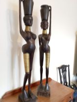 A large pair of Hagenauer style carved wooden figures depicting African women carrying jars on their