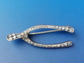 An old rose cut diamond set white metal wishbone brooch, 1.5" - signs of an old repair.