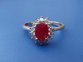 A modern oval ruby & diamond claw set platinum cluster ring - 'Rhapsody'. Finger size O.