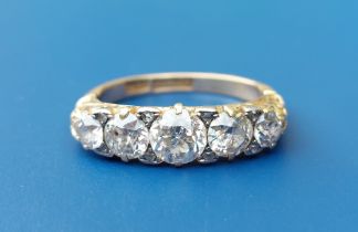 A graduated five stone old cut diamond ring in 18ct gold, the claw set centre stone weighing