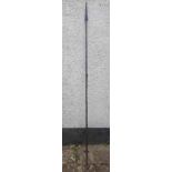 An antique North African spear made from a single piece of iron bound with brass, 74.5".